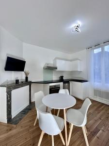 a kitchen with a white table and chairs in a room at T2 Pyrénéen in Pierrefitte-Nestalas