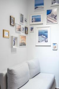 a living room with a white couch and pictures on the wall at The Owl - Stylish Penthouse - Gazi 1BDRM in Athens