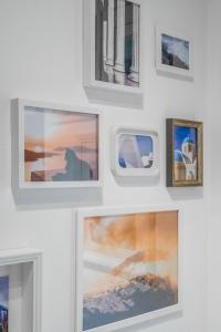 a wall of pictures on a white wall at The Owl - Stylish Penthouse - Gazi 1BDRM in Athens