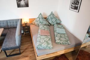 ein Sofa mit vier Kissen darauf im Wohnzimmer in der Unterkunft Stilvolles Studio Apt. Lübeck Zentrum in Lübeck