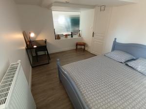 卡萊帕涅的住宿－Tik69，一间卧室配有一张床、一张桌子和一个窗户。