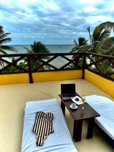 einen Balkon mit einem Tisch und einem Laptop auf einem Bett in der Unterkunft Hotel Luna De Plata in Mahahual