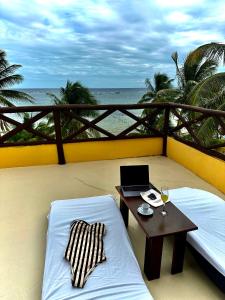a balcony with a table and a laptop on a bed at Hotel Luna De Plata in Mahahual