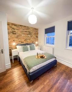 a bedroom with a bed and a brick wall at Stunning Brighton Seaside 2-Bedroom Townhouse with Patio, Sleeps 6 in Brighton & Hove