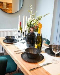 a wooden table with wine bottles and glasses on it at Stunning Brighton Seaside 2-Bedroom Townhouse with Patio, Sleeps 6 in Brighton & Hove