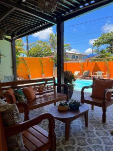 een patio met 2 banken en een zwembad bij Villa Aconchego Guarajuba in Camaçari