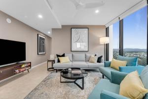 sala de estar con muebles azules y TV de pantalla plana en The Gallery Residences Broadbeach, en Gold Coast