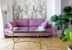 a purple couch in a living room with a table at Lydia in Ermoupoli