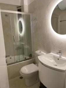 bagno con servizi igienici, lavandino e specchio di Four Seasons Sea View Apartment ad Atene