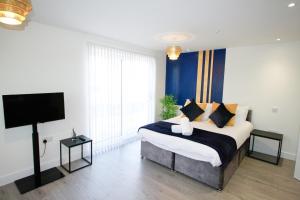 a bedroom with a large bed and a flat screen tv at Modern Studio for LONG STAY BUSINESS & RELOCATIONS in Hemel Hempstead
