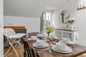 a dining room with a wooden table with dishes on it at Stunning Sea View Whole Home In Torbay Close To Beach in Torquay