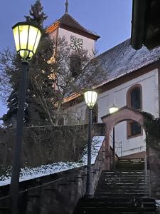 a building with a clock tower and two street lights at FeWo unter der Kirche in Broggingen