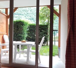 a white table and white chairs on a patio at Appartement 2 chambres avec jardinet, piscine vue sur la montagne in Luz-Saint-Sauveur