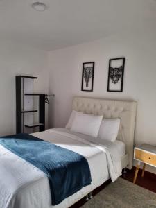 a bedroom with a bed and three pictures on the wall at Florentina in Tunja