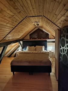 a bed in a room with a wooden ceiling at Piece of Heaven in Samobor