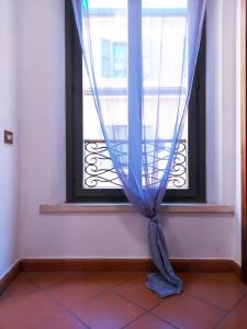 a window with a blue curtain in a room at Loft Garibaldi in Correggio