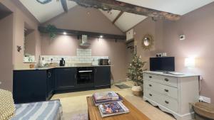 a living room with a kitchen and a table at Rural Retreat, Wood Burner, Patio, Lawn, Breakfast, new wifi in Warminster