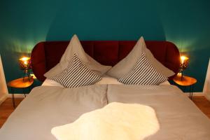 1 cama con sábanas y almohadas blancas y 2 lámparas en Allgäu Retreat en Bad Wörishofen