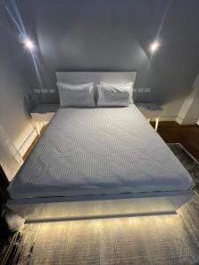 een groot wit bed in een kamer met 2 verlichting bij Paris east in Caïro