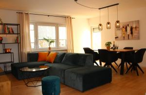ein Wohnzimmer mit einem schwarzen Sofa und einem Tisch in der Unterkunft Allgäu Retreat in Bad Wörishofen