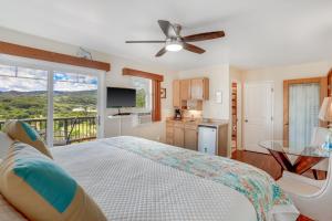 a bedroom with a large bed and a balcony at Marjorie's Kauai Inn in Lawai