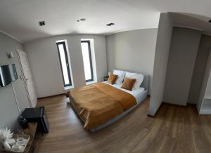 um quarto com uma cama com paredes e janelas brancas em Hostel Węgierki em Węgierki