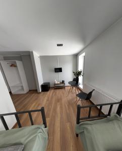 uma sala de estar com duas camas e uma televisão em Hostel Węgierki em Węgierki