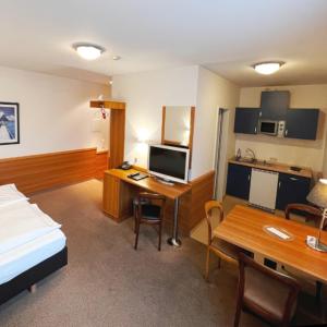 ein Hotelzimmer mit einem Bett und einem Schreibtisch mit einem Computer in der Unterkunft Hotel Höllsteiner Hof in Steinen