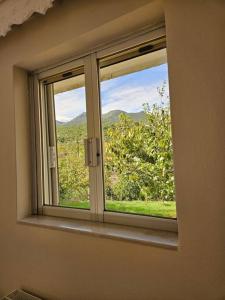 uma janela com vista para um campo verde em Tilfousa's Home em Ipsilándis