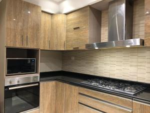 a kitchen with a stove and a microwave at Sheraton Ocean 803 - Private apartments in Cairo