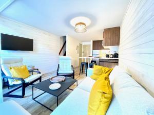 a living room with a couch and a table at Centre village Appartement 3 chambres avec terrasse Jusqu'à 6 personnes in Saint-Lary-Soulan
