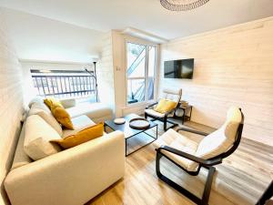a living room with a couch and a table at Centre village Appartement 3 chambres avec terrasse Jusqu'à 6 personnes in Saint-Lary-Soulan