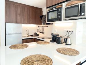 a kitchen with a white counter top with a microwave at Centre village Appartement 3 chambres avec terrasse Jusqu'à 6 personnes in Saint-Lary-Soulan +5 photos
