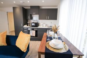 una cocina con una mesa de madera con platos y copas de vino en Modern Studio for LONG STAY BUSINESS & RELOCATIONS en Hemel Hempstead