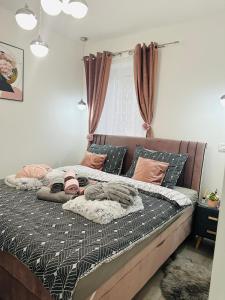 ein Bett mit Decken und Kissen darauf in einem Schlafzimmer in der Unterkunft Apartman Jovičić in Bjelovar