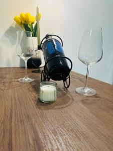 a table with two wine glasses and a camera on it at Apartman Jovičić in Bjelovar