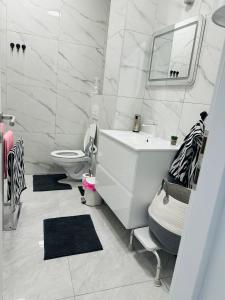 a white bathroom with a sink and a toilet at Apartman Jovičić in Bjelovar +7 photos