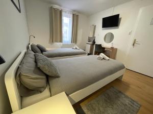 - une chambre avec 2 lits et une télévision dans l'établissement Pension Bären, à Großengstingen