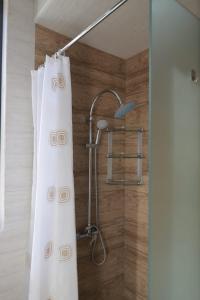 La salle de bains est pourvue d'une douche avec un rideau de douche blanc. dans l'établissement Modern House 2, à Dilidjan