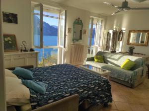 a bedroom with a bed and a couch and a window at Camilla House in Varenna
