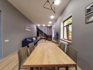 a dining room with a table and a blue couch at Lady and Bear GH in Sǝrdakhar