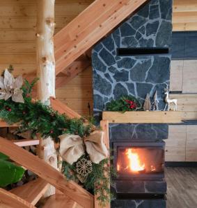 a fireplace in a log cabin with christmas decorations at Hamajdówka in Zubrzyca Górna