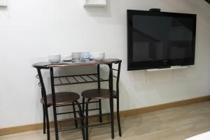 a table with two stools and a television on a wall at La Piccola Mole - Turin Cozy Apartment in Turin
