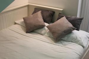 a white bed with pillows on top of it at La Piccola Mole - Turin Cozy Apartment in Turin
