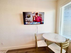 a television hanging on a wall with a table and chairs at The Rivet Apartments in Reno