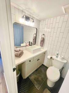 bagno con servizi igienici, lavandino e specchio di The Rivet Apartments a Reno