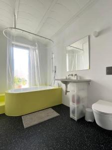 ein Badezimmer mit einer grünen Badewanne und einem Waschbecken in der Unterkunft Design & art, patio with orange tree, near Seville in Carrión de los Céspedes