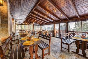 a dining room with tables and chairs and windows at N.Joy Holiday Apartment 532 by Oak Residence in Smolyan