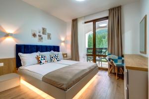 a bedroom with a large bed and a balcony at N.Joy Holiday Apartment 532 by Oak Residence in Smolyan