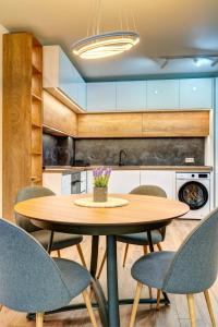 a kitchen with a wooden table and chairs at N.Joy Holiday Apartment 532 by Oak Residence in Smolyan